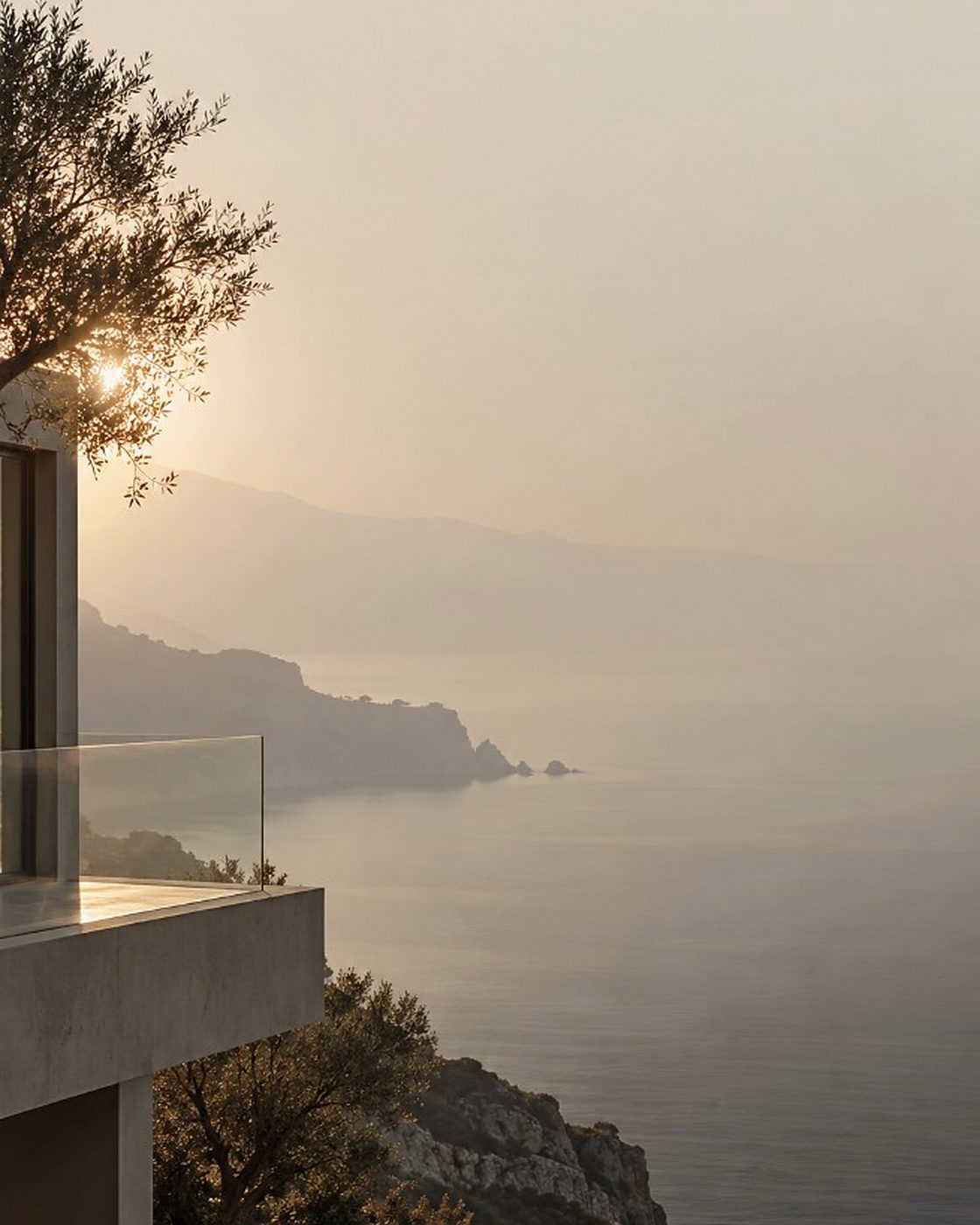 Hillside terrace above a hazy Mediterranean coastline at sunset